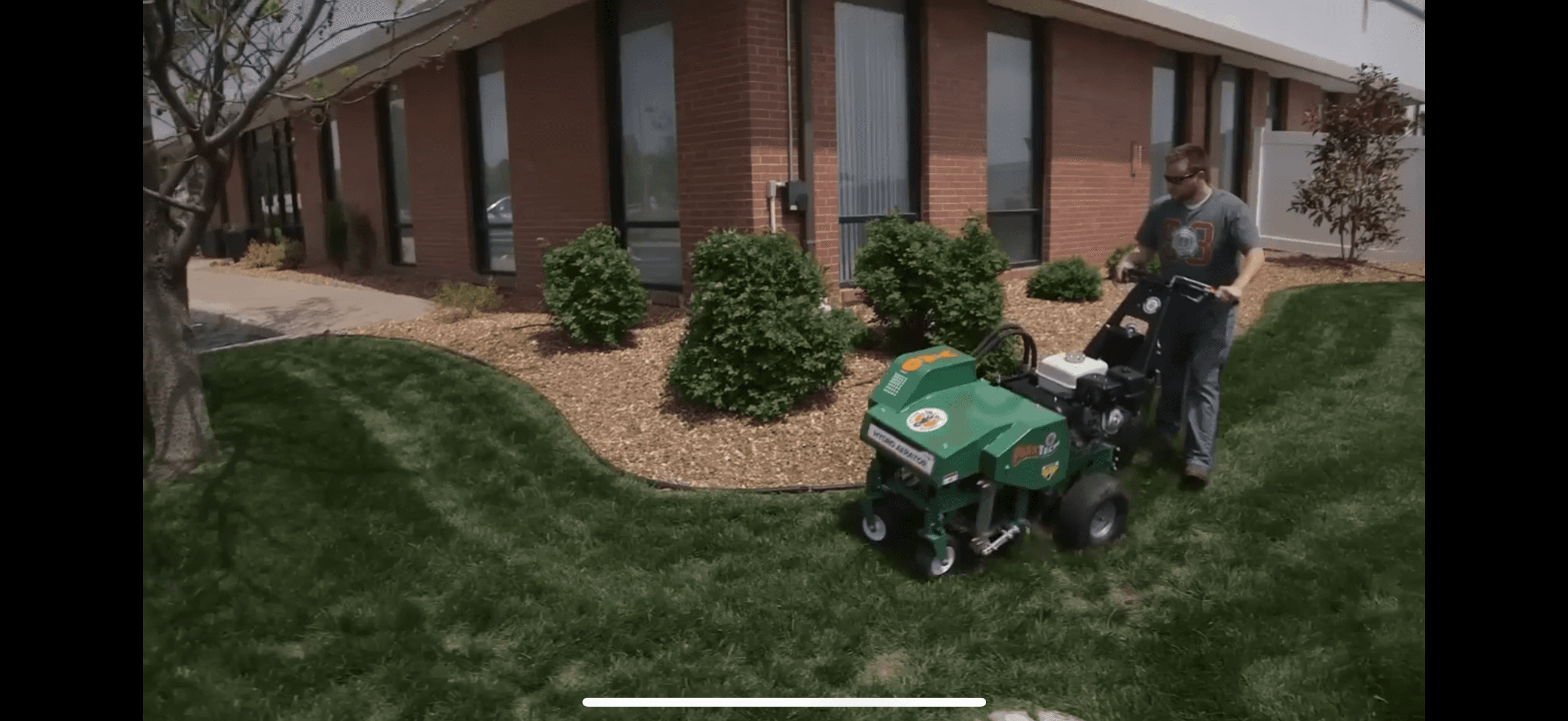 Core lawn aeration along the landscape beds near the home